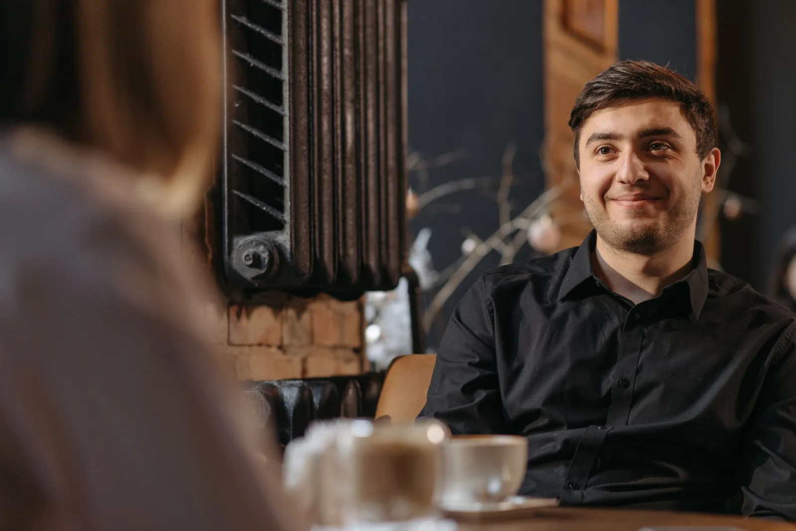 A man smiling while meeting someone new.